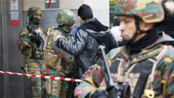 Belgian troops search people entering a subway station